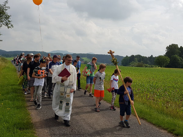 Unterwegsgottesdienst mit Stadtpfarrer Stefan Buß. Das Pilgerkreuz geht voran.